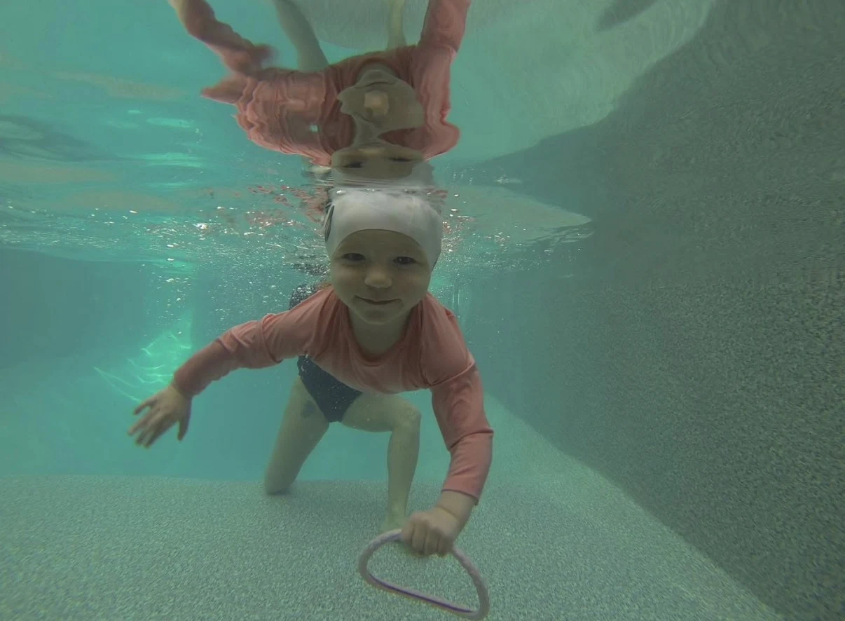 A young swimmer exploring underwater during a lesson